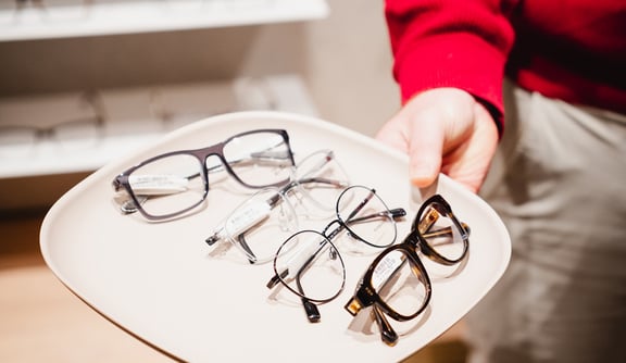 Eine Brillenauswahl aus vier Brillenfassungen präsentiert auf einem Tablett
